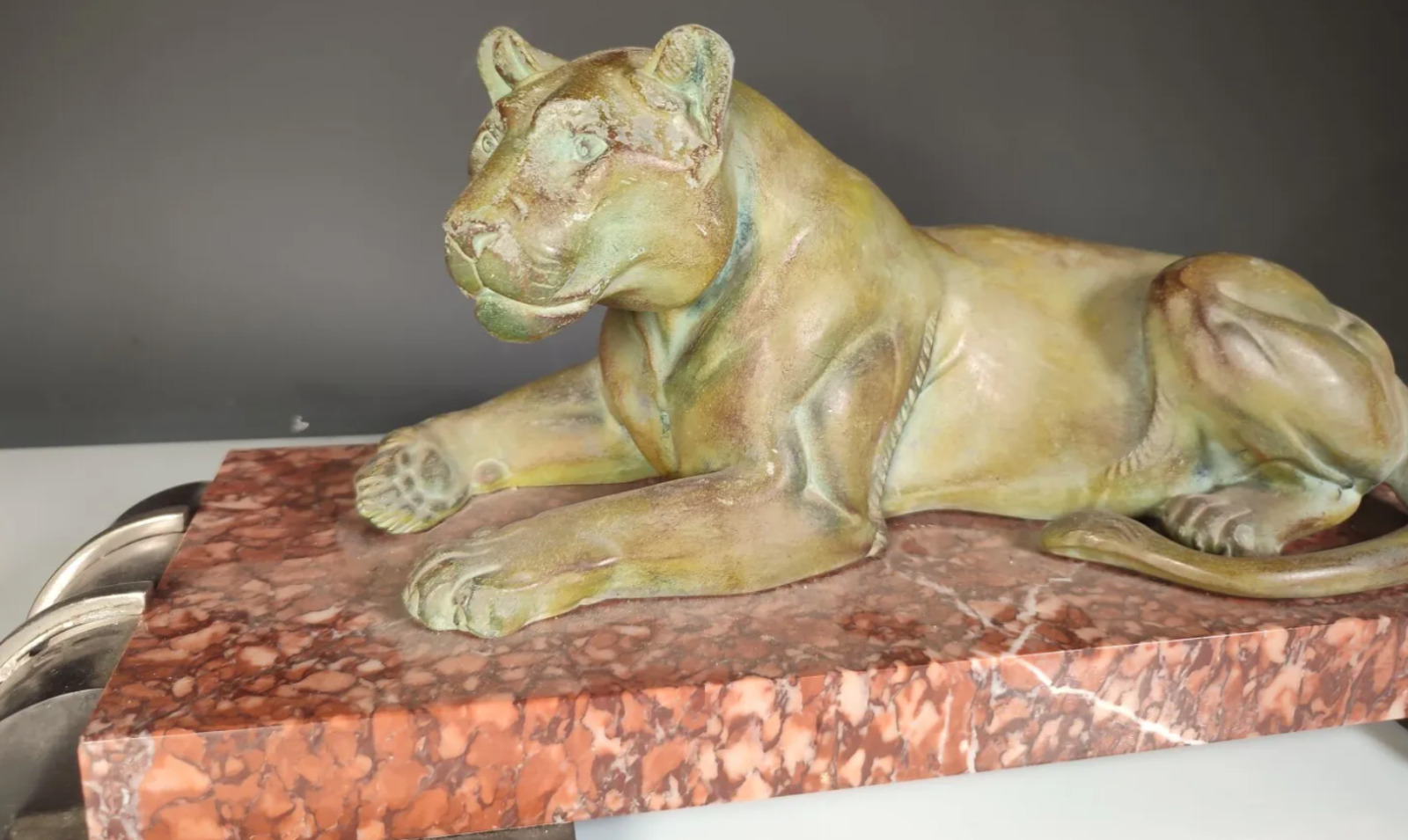 Lionne allongée Art Déco en régule à patine verte, sur un socle en marbre 49cm